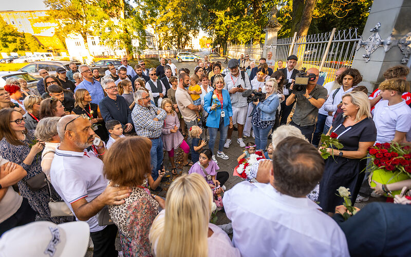 Eine Gruppe von Menschen steht im Kreis um die Stelle, an der die Stolpersteine gesetzt wurden, darunter auch die Bürgermeisterin Simone Taubenek.