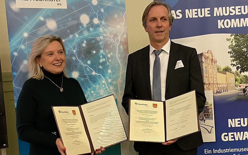 Bürgermeisterin Simone Taubenek und Prof. Dr. Mario Ragwitz vom Fraunhofer IEG Cottbus halten die aufgeschlagenen Mappen mit dem Letter of Intent „Zukunftslabor im neuen Museum“ vor sich in die Kamera.